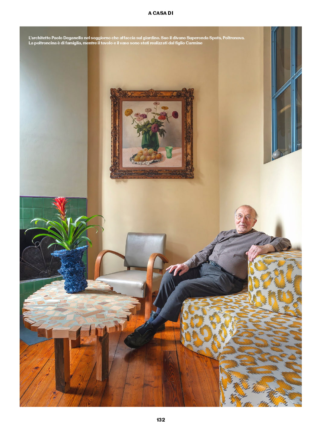 Paolo Deganello sitting on the Superonda Spots sofa in the living room, with a family armchair, a table and a vase made by his son Carmine.