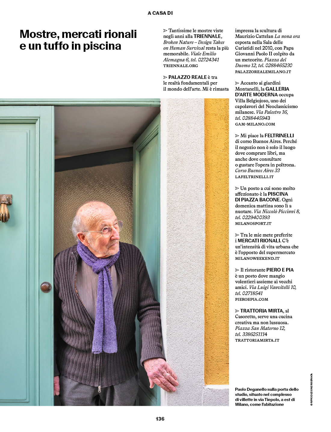 Paolo Deganello standing in the doorway of his Milan home, wearing glasses and a purple scarf.